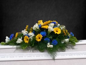 Kukkalaite sinisillä, keltaisilla ja valkoisilla kukilla