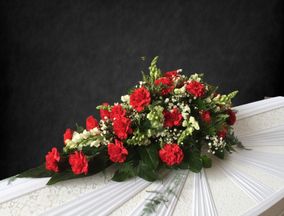 Punaisista ja valkoisista kukista sidottu kukkalaite